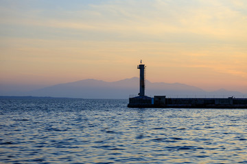 lighthouse at sea at sunset