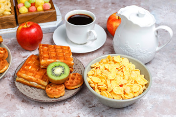 Breakfast with various sweets,wafers,corn flakes and a cup of coffee,top view