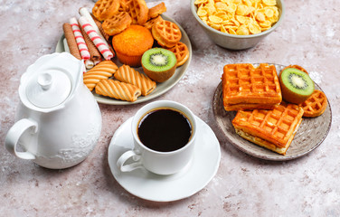 Breakfast with various sweets,wafers,corn flakes and a cup of coffee,top view