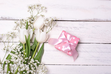 Spring tulip flowers, gift box and paper card on gray stone table from above in flat lay style. Greeting for Womens or Mothers Day.