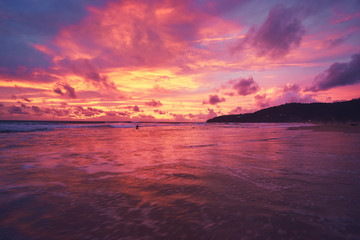 Beautiful sunset on ocean beach. Sky is reflecting at water.