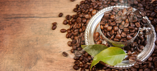 Coffee cup and beans on old kitchen table.