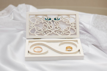 wedding rings in a wooden box on a glass table