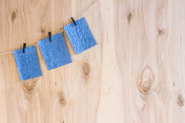 three blue sheets on clothespins hang on thread