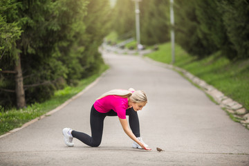 beautiful young woman in sportswear in a summer park plays sports