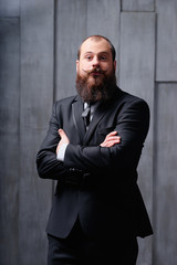 Gentleman fashion and style. Handsome young bearded man at suit and tie.