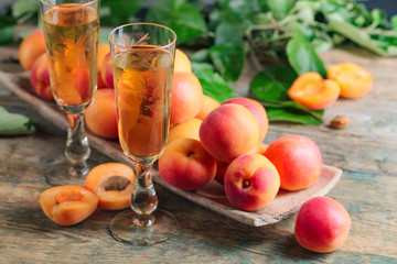 Apricot liqueur and juicy fruits on a wooden table.