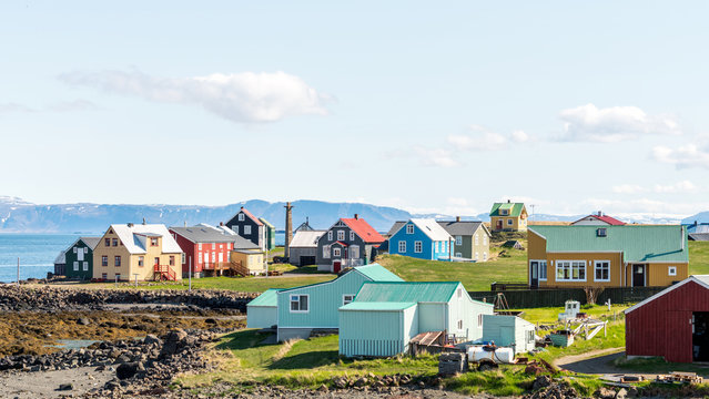 Colorful buildings and the charming city of Flatey Island in Iceland just outside Stykkisholmur and the Westfjords. Blue sky and sunny weather. Explore and traveling concept.
