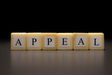 The word APPEAL written on wooden cubes isolated on a black background...