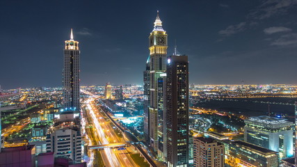 Plakat Scenic Dubai downtown architecture night timelapse. Top view over Sheikh Zayed road with illuminated skyscrapers and traffic.