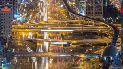 Aerial view of highway junction with traffic timelapse in Dubai, UAE, at night. Famous Sheikh Zayed...