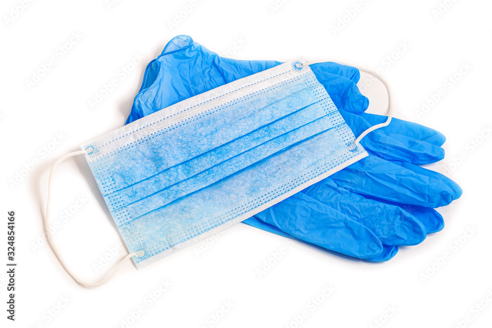 Wall mural Disposable rubber medical gloves and mask. Protective subjects. Remedies. A pair of thin blue medical latex gloves and face shield on a white background.