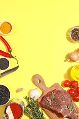 Raw beef antricot on yeiiow background. Composition with rosemary, hot pepper and other spices for cooking meat. A look from above. close-up