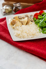 Pieces of chicken fillet cooked in a cream sauce with mushrooms and lemon juice, served with rice.