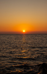 beautiful Sunny sunset on the sea. Amazing summer view on the beach.  blazing sunset landscape at black sea and orange sky above it with awesome sun golden reflection on calm waves.