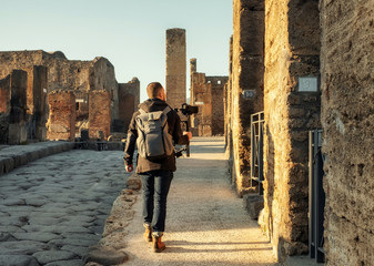 Videographer filming ruins of famous Pompeii city, Italy