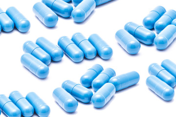 Blue capsules isolated on white. Medicine healthcare background. Drugs dose in group. Painkiller...
