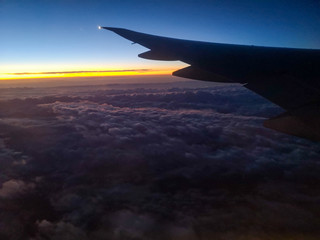 Fototapeta na wymiar Dawn of the sun in the window of an airplane