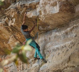 Strong fit woman rock climbing up high