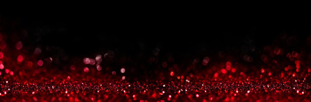 Abstract blur red glitter on black background. Card for Valentine's day, christmas and wedding celebration. Love bokeh sparkle confetti textured layout.
