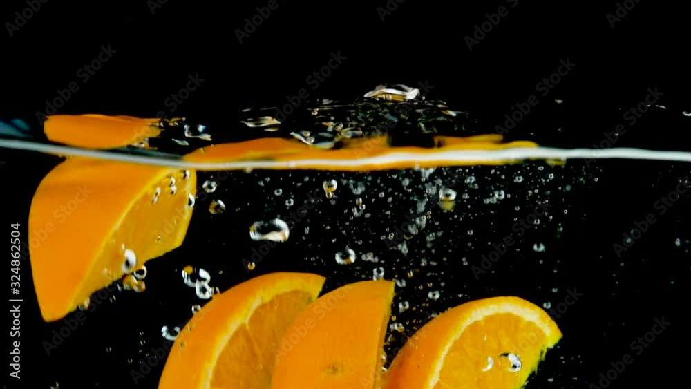 Wall mural orange falling in water- slow motion