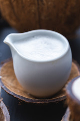 Coconut milk in a white cup on a coconut bark cup.