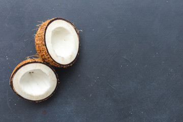 Sliced coconut on a dark table. Flat lay scene for copy space and background.