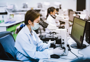 medical technician look at the microscope  in medical laboratory