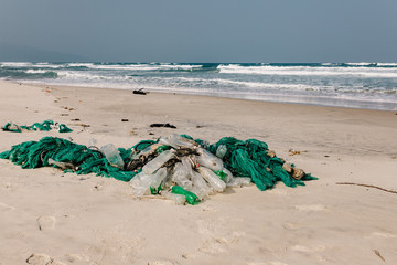 Fototapeta na wymiar Old fishing net thrown to the seashore. trash on the sea beach. ecological problem. Environmental pollution.
