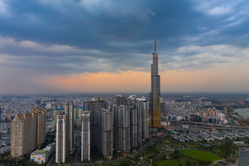 Dramatic aerial view of Landmark Building and Ho Chi Minh City skyline at sunset with beautiful stormy and dark clouds in the sky