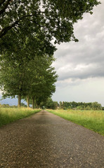 Fototapeta na wymiar Threatening dark rainy clouds are covering a rural landscape, showing the Overcast and gloomy sky above the countryside creating a beautiful and impressive dramatic scenery