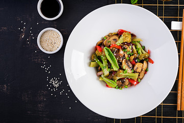 Stir fry vegetables with mushrooms, paprika, red onions and broccoli. Healthy food. Asian cuisine. Top view, overhead