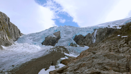 Glacier Buarbreen view with white clouds and blue sky line seamless endless timelapse near Odda Folgefonna National Park during summer hiking in Hordaland Norway Europe