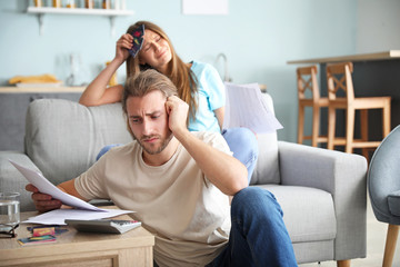 Worried young couple in debt at home