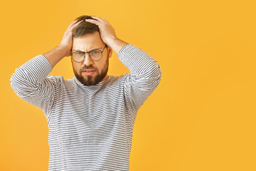 Worried young man on color background