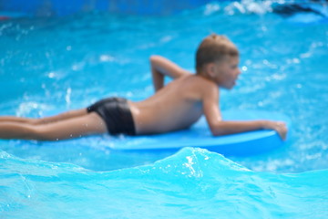 Fototapeta na wymiar Baby boy on a water Board. Stay in the water Park in the summer.