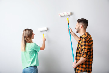 Young couple painting wall in new apartment