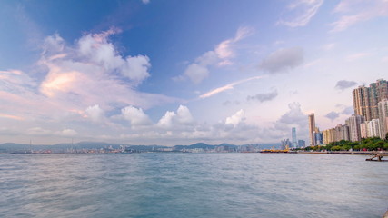 Hong Kong, China skyline panorama day to night from across Victoria Harbor timelapse.