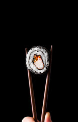 Close up maki roll in chopsticks