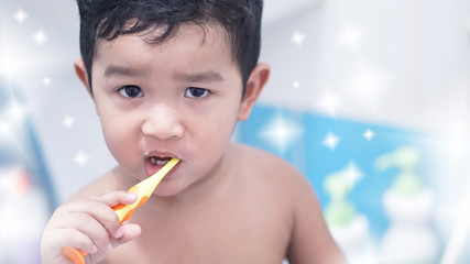 Cute funny little Asian kid 2 year old. Toddler boy, child do not wear a shirt. He holding toothbrush and doing brushing his teeth. Tooth care for children concept.                                    