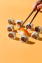 Chopsticks picking nigiri sushi out of maki rolls © FreepikCompany
