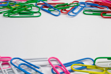 Colorful paper clips isolated on white with free space in the centre.