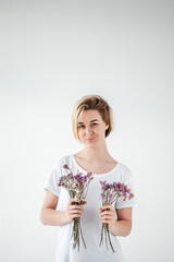 young woman with purple flowers on the light background.  - 324882110