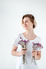 young woman with purple flowers on the light background.  - 324882126