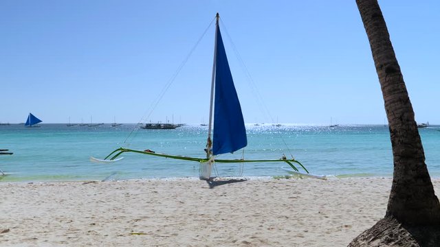 Slow motion of traditional paraw sailing boat from native Visayas is docking at tropical white sand beach of Boracay - Philippines