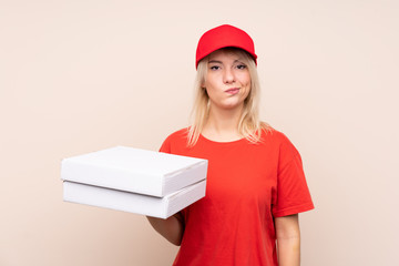 Pizza delivery Russian woman holding a pizza over isolated wall with sad expression