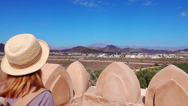 Young Foreign Female Tourist Enjoying Landscape View of Oman from Jabreen Castle. Caucasian Woman in Active Solo Travel in Middle East Countries