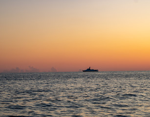 Fototapeta na wymiar Sunset on the Black Sea of Sochi and a ship on the horizon