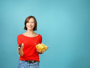 Beautiful woman holding chips on  blue background