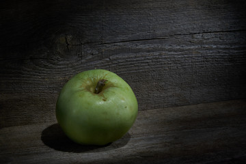 Green apple on wooden table close up with copy space